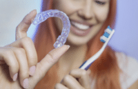 Top benefits of invisalign for teens 2 Teen holding invisalign teen and toothbrush, representing teens