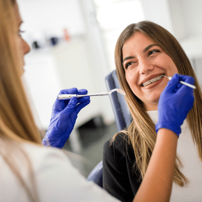 Your first orthodontic appointment: a step-by-step guide 4 A woman smiling at a dentist, representing your first orthodontic appointment