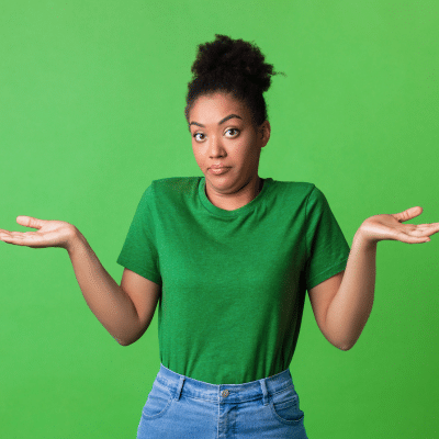 Braces vs invisalign 2 Woman in green shirt, shrugging hands on a green background, representing braces vs invisalign